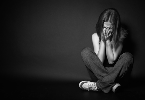 woman in depression and despair crying on black dark